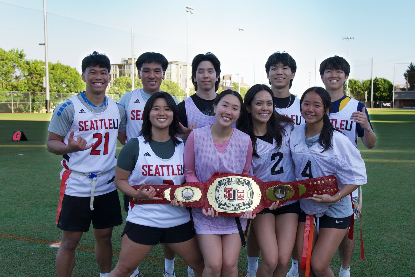 A team in Seattle University jerseys holding an intramural championship belt on the field