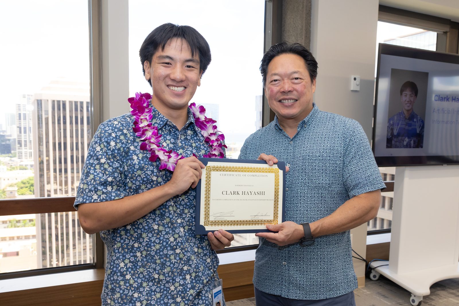 Clark receiving a certificate from Bank of Hawaii CEO Peter Ho